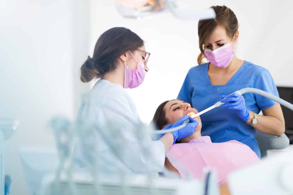 Dentist And Assistant Conducting Root Canal Treatment
