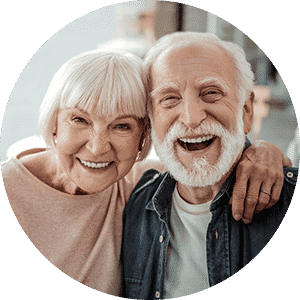 An elderly Couple smiling showing off their new dentures